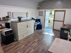 Una cocina compacta equipada con microondas, cafetera y un mueble con cajones.