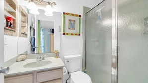 A bathroom with a white sink, a toilet, and a shower enclosure. - Lakefront Townhome.  Steps to Private Beach. Large Decks (Destin)