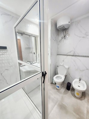 Ein modernes Badezimmer mit Duschkabine aus Glas, Toilette, Bidet und Luftreiniger an der Wand.