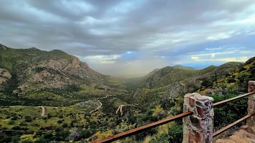 A mountainous landscape with a dirt path leading through a valley.