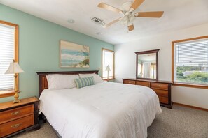 A bedroom with a bed, a nightstand, a dresser, a ceiling fan, and a window with blinds. - Sandpiper - Whalehead, Semi-Oceanfront, Pool, Hot Tub, Pets OK, YR Flex Stays (Corolla)