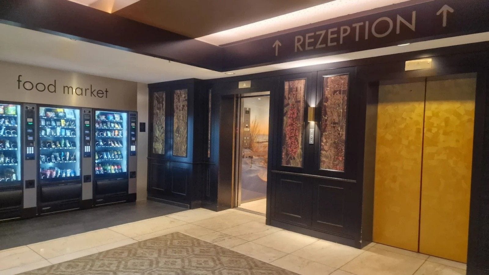 A reception area with a sign for the food market and vending machines.