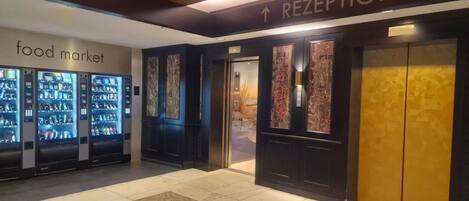 A reception area with a sign for the food market and vending machines.