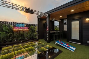 A modern outdoor area with a neon sign, artificial grass, and a pool table. - Ultimate Nashville Fun House ~ Rooftop Dance Floor | Hot Tub | Sauna | Games | Sleeps 16 (Nashville)