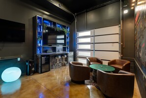 A modern interior with a pool table, leather chairs, and a bar area. - Ultimate Nashville Fun House ~ Rooftop Dance Floor | Hot Tub | Sauna | Games | Sleeps 16 (Nashville)