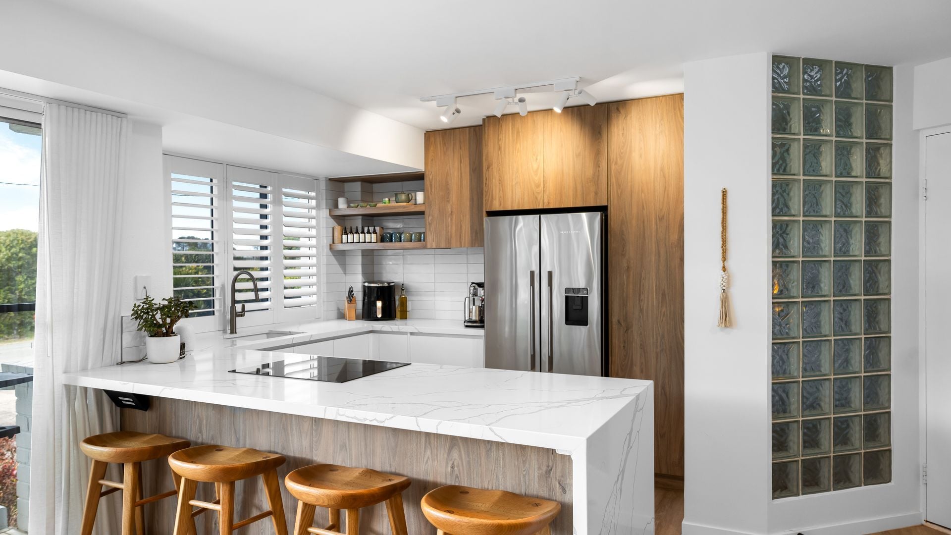 A modern kitchen with a large island, stainless steel appliances, and wooden accents.
