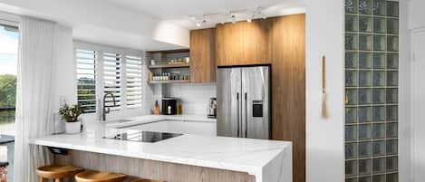 A modern kitchen with a large island, stainless steel appliances, and wooden accents.