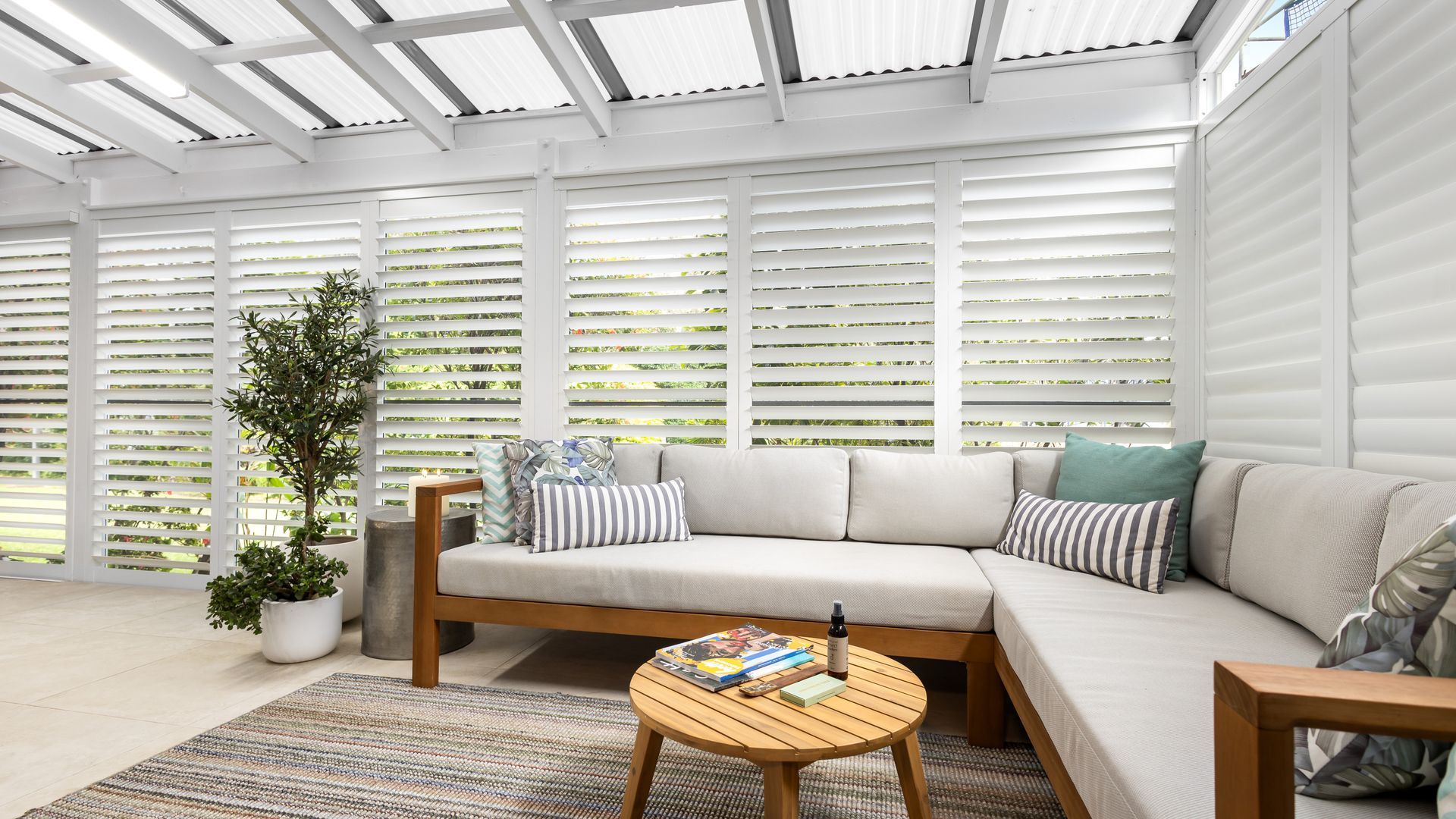 A modern living room with a sectional sofa, a coffee table, and a potted plant.