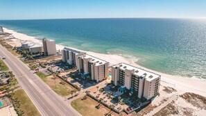 A coastal hotel with multiple buildings, a parking lot, and a beach view. - Gulf Front | Huge Balcony | Direct Beach Access | BEACHBALL PROPERTIES (Orange Beach)