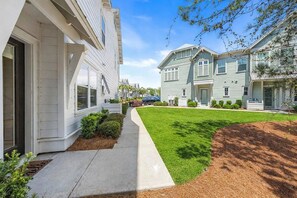A residential street with houses, a sidewalk, and a grassy area. - 🦩Book Me Baby! Chillin' in Prominence🦩 (Inlet Beach)