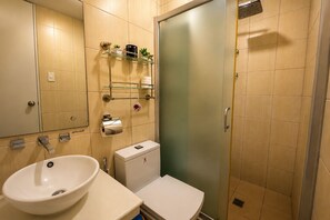 Un bagno con lavandino, servizi igienici e cabina doccia in vetro.