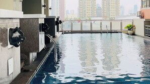 Ein Schwimmbecken mit Blick auf hohe Gebäude im Hintergrund.