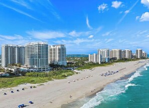 A beachfront hotel with multiple high-rise buildings, a sandy beach, and ocean waves. - Breathtaking, rare 3-bedroom condo at Luxury Amrit Ocean Resort on Singer Island (Singer Islad)