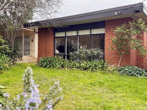 A residential building with a brick facade, large windows, and a well-maintained garden. - 3BR Belmont House | Walk to High St Shops (Belmont)