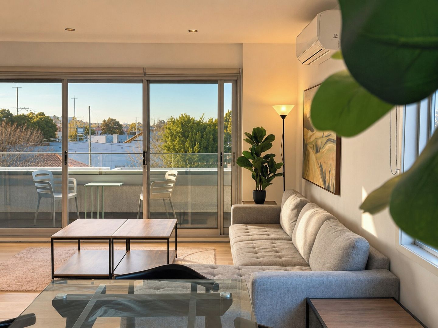 Uma sala de estar moderna com uma mesa de vidro, um sofá e um vaso de planta.