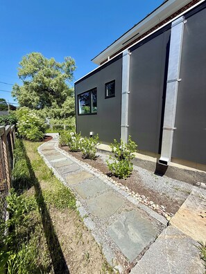 A modern building with a stone pathway leading to the entrance. - Sun-Filled Brick Townhouse Near Downtown Bath (Bath)