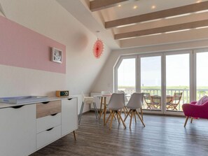 A modern interior with a dining area, white furniture, and large windows. - 54-degree Panoramic View (St. Peter-Ording)
