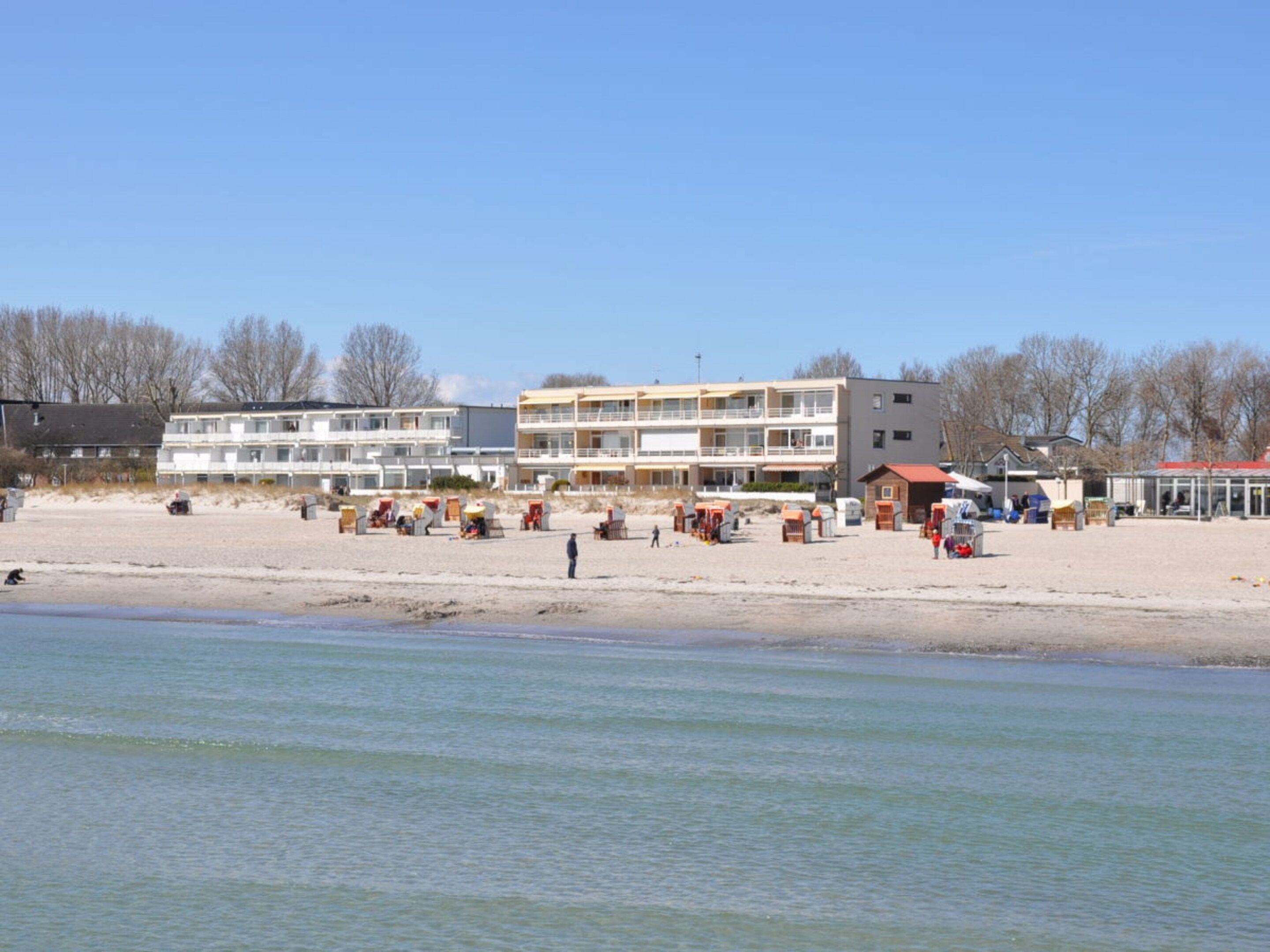 A beachfront hotel with multiple balconies, beachside amenities, and a sandy beach.