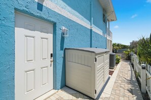 A building with a blue exterior, a white door, and a white garage door. - 5BR Beachfront Escape | Private Beach Access (Cape Canaveral)