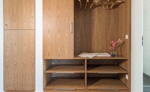 A wooden wardrobe with a shelf and a hanging space.