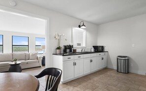 A modern kitchen with white cabinets, a black countertop, and a stainless steel trash can. - Lake Eufaula Cottage-Gorgeous Lake Views-Kayaks-Fire Pit-Near Boat Ramp & Golf (Canadian)