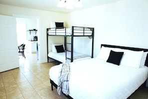 A dormitory room with bunk beds, a single bed, and a kitchenette. - Lake Eufaula Cottage-Gorgeous Lake Views-Kayaks-Fire Pit-Near Boat Ramp & Golf (Canadian)