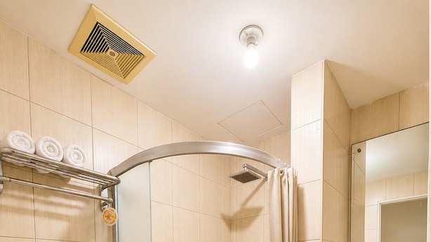 Ein Badezimmer mit Dusche, Toilette, Waschbecken und Spiegel.