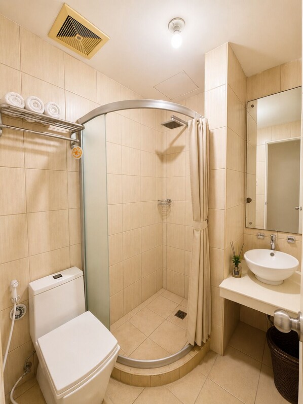 Un bagno con doccia, toilette, lavandino e specchio.