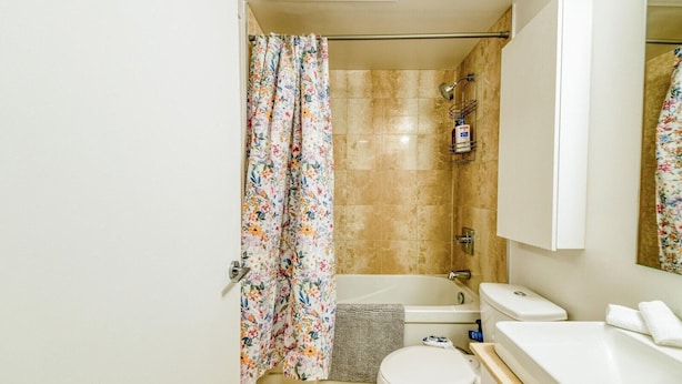 Ein Badezimmer mit Dusche, Toilette und Waschbecken.