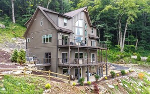 A multi-story house with a balcony, surrounded by a forested landscape. - 02 Blue Ridge Mountains View - House & Resort (Boone)