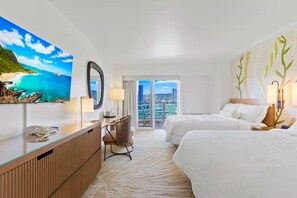 Habitación de hotel con cama, escritorio, silla, ventana grande y un cuadro de una playa.