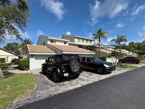 A residential area with a house featuring a tiled roof and a driveway. - Charming Coastal 1-bedroom condo in wonderful Nokomis, 1 mile from the beach! (Nokomis)