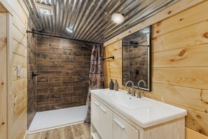A bathroom with a shower, a sink, and a mirror. - Welcome to the Sheriff's Office (Stanton)