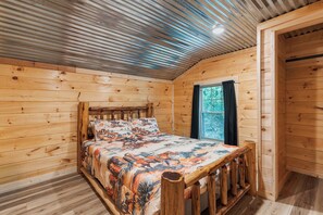 A wooden cabin room with a bed, a window, and a door. - Welcome to the Sheriff's Office (Stanton)