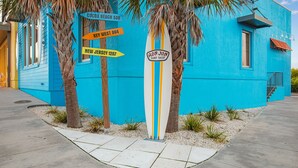 Ein lebhaft blaues Gebäude mit Hinweisschildern für Cocoa Beach, Key West und New Jersey.
