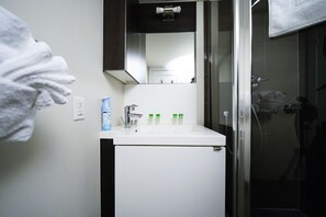 A bathroom with a white sink, a mirror, and a shower area. - Spacious 2BR/2BA Downtown Suite with Sofa Bed - Near Toronto Attractions! (Toronto)