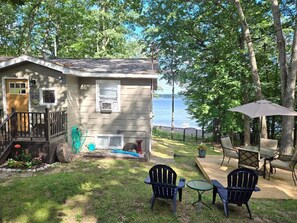 A cabin with a deck, outdoor seating, and a view of the lake. - Charming 3-bedroom house on Fife Lake perfect for enjoying any season (Fife Lake)