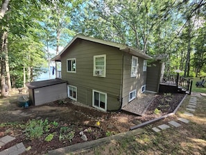 A two-story house with a front porch, a garage, and a small deck. - Charming 3-bedroom house on Fife Lake perfect for enjoying any season (Fife Lake)