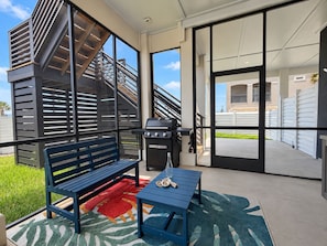 Eine moderne Außenpatio mit Grill, einer Bank und einem gemusterten Teppich.