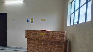 Un comptoir d’accueil avec un plateau en marbre, une porte à gauche et une fenêtre à droite.