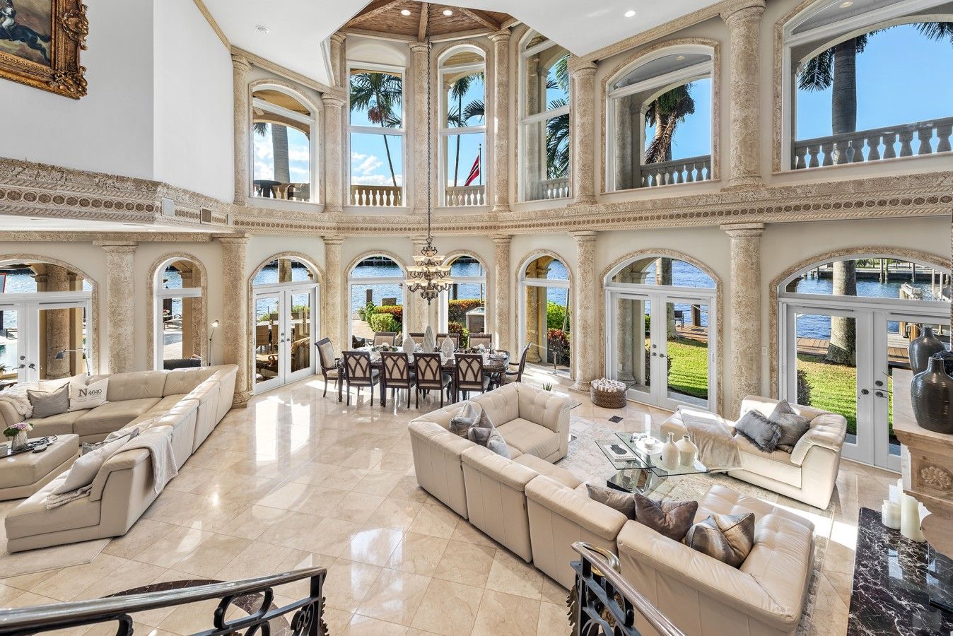 A spacious interior with a central dining area, multiple seating arrangements, and large windows providing views of the outdoors.