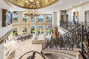 A grand interior with a staircase, a dining area, and a view of the outdoors. - The Palazzo | Waterfront | Walk to Beach | Luxury Villa (Fort Lauderdale)