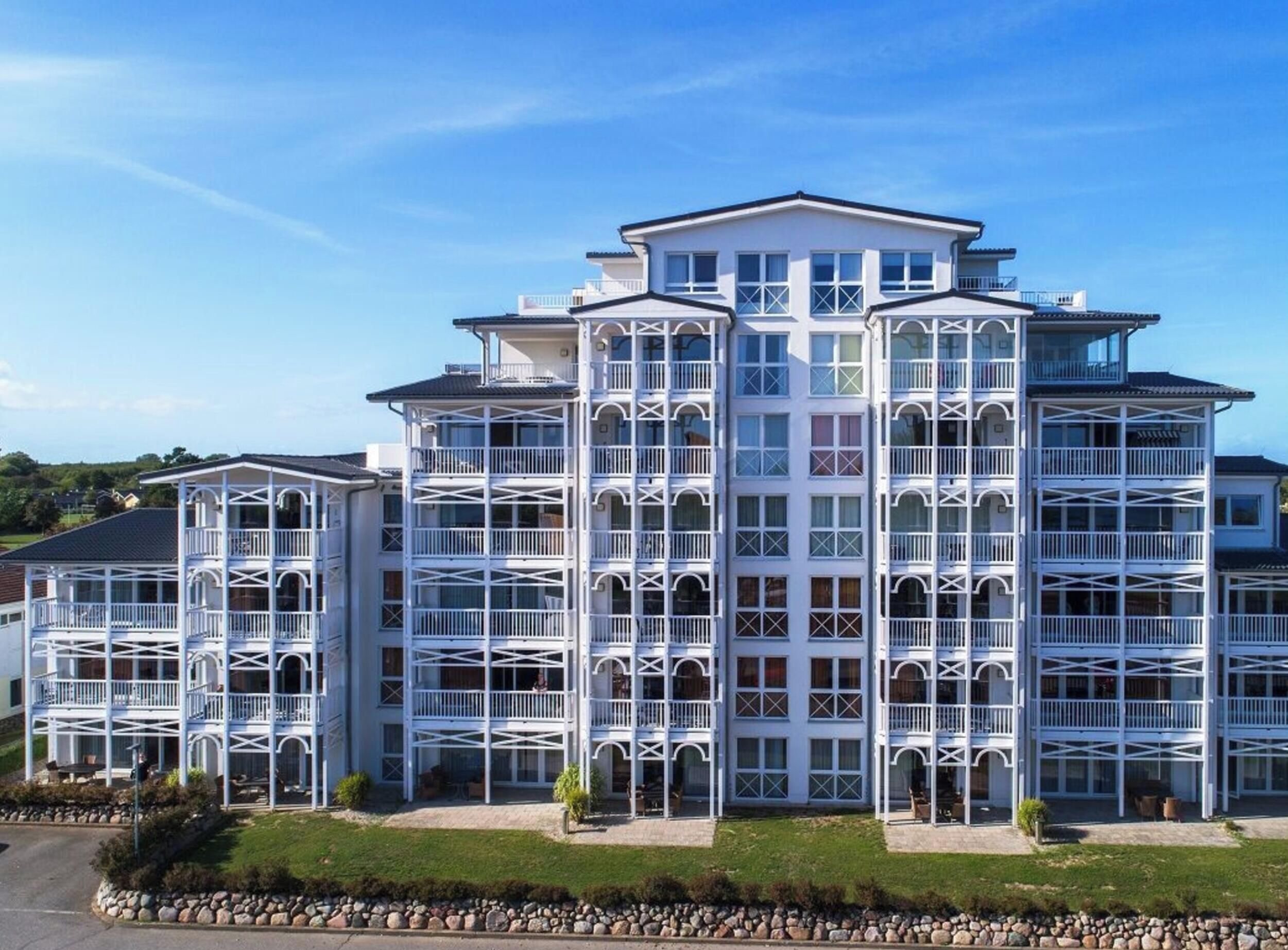 A multi-story hotel with a symmetrical facade, balconies, and a central entrance.