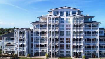 A multi-story hotel with a symmetrical facade, balconies, and a central entrance.