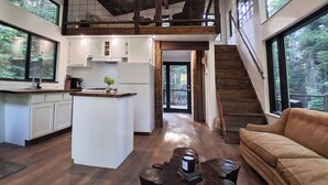 Una cocina amplia con una isla central, vigas de madera y grandes ventanales que ofrecen vistas al exterior.