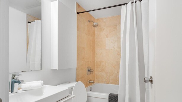 Ein modernes Badezimmer mit Toilette, Waschbecken und Duschbereich.