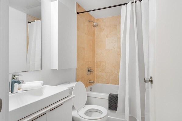 A modern bathroom with a toilet, sink, and shower area. - Executive 1BR Hotel Suite with Sofa Bed | Toronto (Toronto)