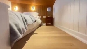 Ein Hotelzimmer mit einem Bett, einem Nachttisch und einer Lampe.
