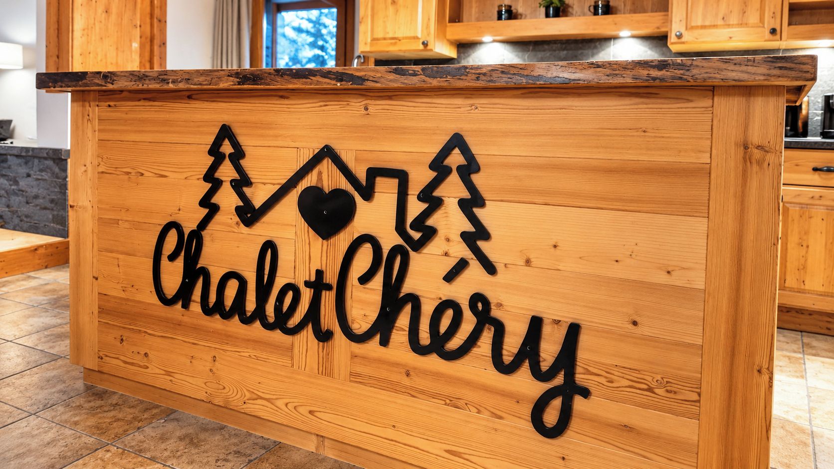 Un bancone bar in legno con un cartello che riporta 'ChaletChéry' e decorazioni a forma di montagna e cuore.