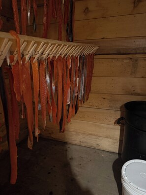 Une pièce aux murs en bois, avec un portant suspendu où sont accrochés divers objets.
